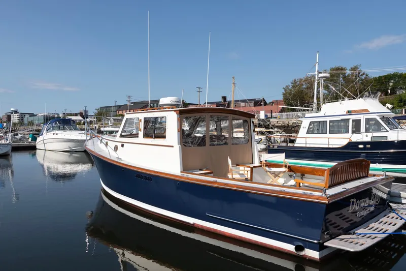 Slide: The Image of 1985 Wilbur 34 boat docked in a marina under clear blue skies. - 21