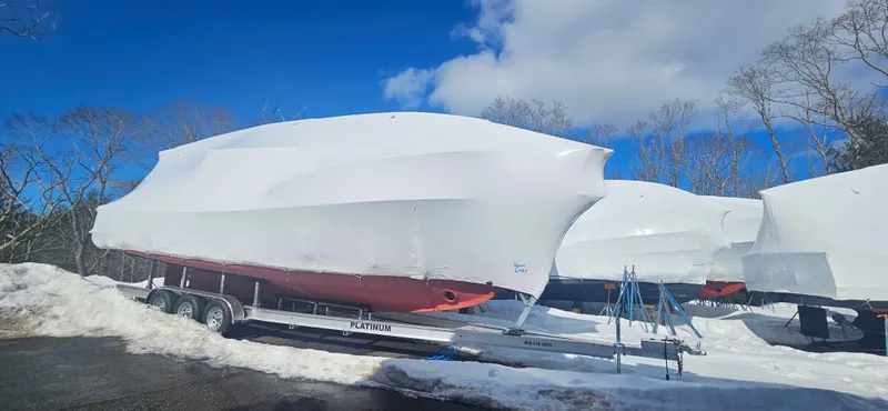Slide: The Image of 1985 Wilbur 34 boat covered in white tarp on trailer, snowy landscape. - 27