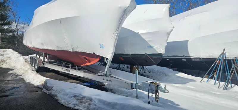 Slide: The Image of Covered Wilbur 34 boats from 1985 on trailers in snowy storage area. - 29
