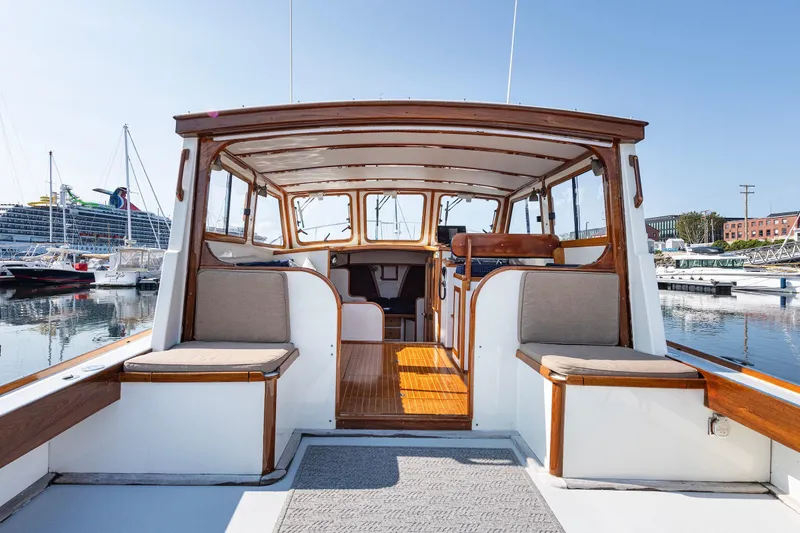 Slide: The Image of 1985 Wilbur 34 boat interior with wooden accents, docked at a marina. - 5