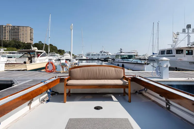 Slide: The Image of 1985 Wilbur 34 boat docked at marina with surrounding yachts and clear sky. - 7