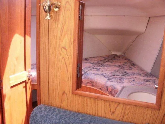 Slide: The Image of Cozy cabin interior of 2000 Hunter 380 sailboat with wood paneling and bedding. - 16
