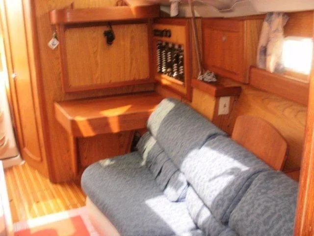 Slide: The Image of Cozy interior of 2000 Hunter 380 sailboat with wooden furnishings and cushioned seating. - 18