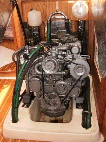 Slide: The Image of Engine of a 2000 Hunter 380 sailboat, featuring complex mechanical components and green hoses. - 24