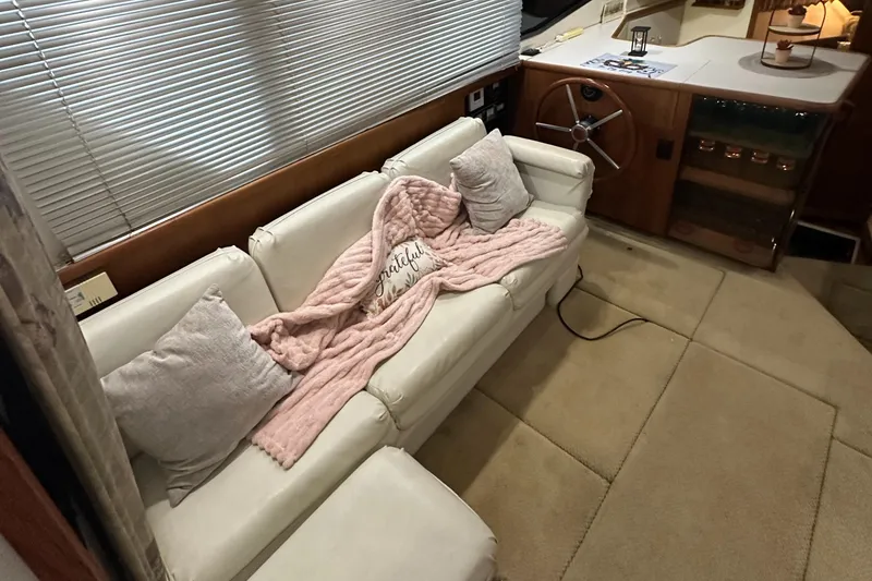 Slide: The Image of 1991 Carver 33 Aft Cabin interior with white sofa, pink blanket, and helm station. - 15