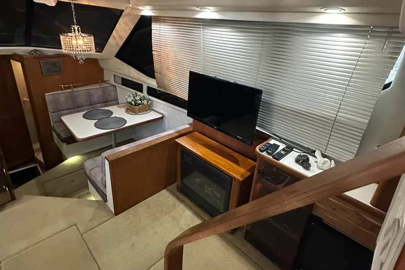 Slide: The Image of 1991 Carver 33 Aft Cabin interior with dining area, TV, and modern decor. - 16
