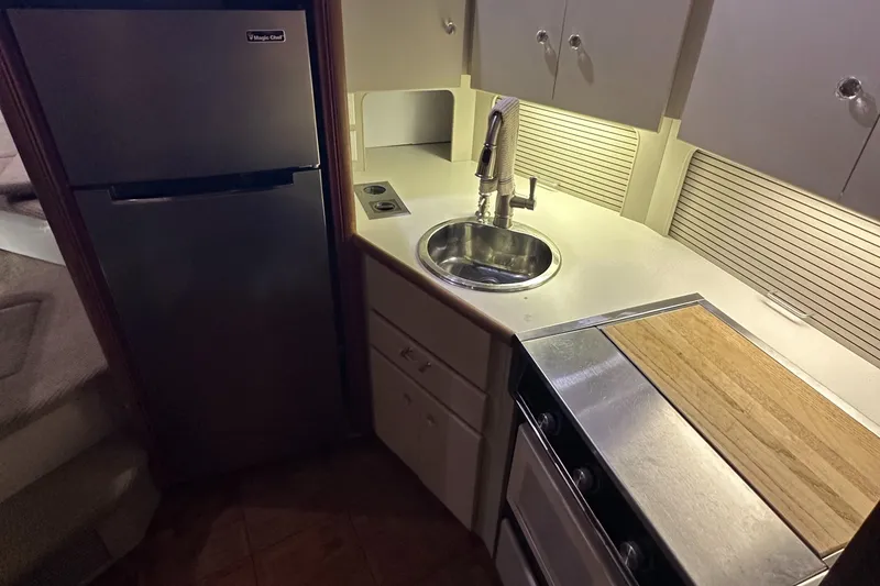 Slide: The Image of 1991 Carver 33 Aft Cabin kitchen with sink, stove, and refrigerator. - 27