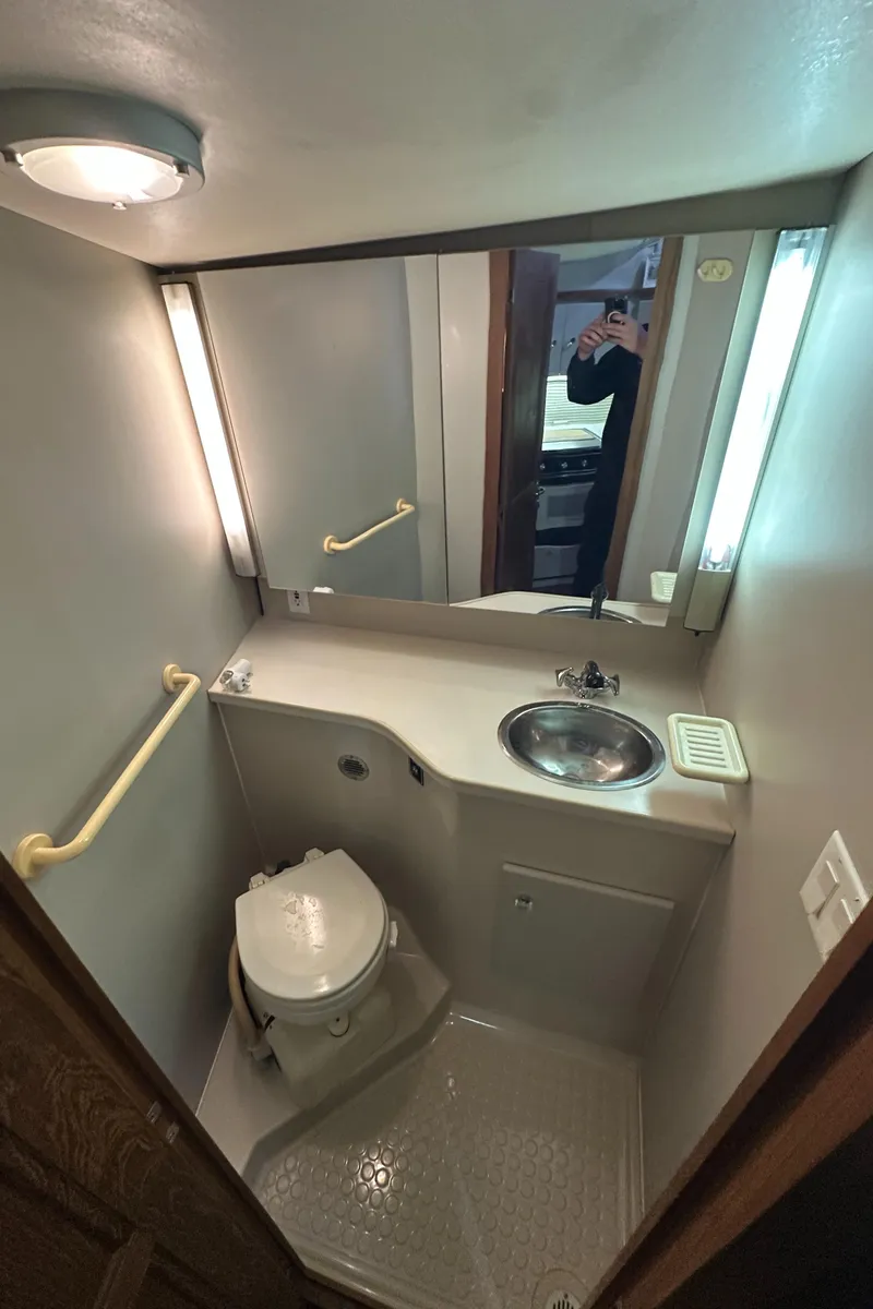 Slide: The Image of 1991 Carver 33 Aft Cabin bathroom with sink, toilet, and mirror. - 32