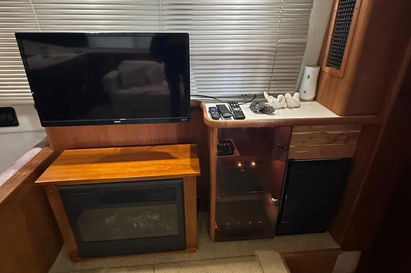 Slide: The Image of Interior of 1991 Carver 33 Aft Cabin with TV, fireplace, and cabinets. - 17