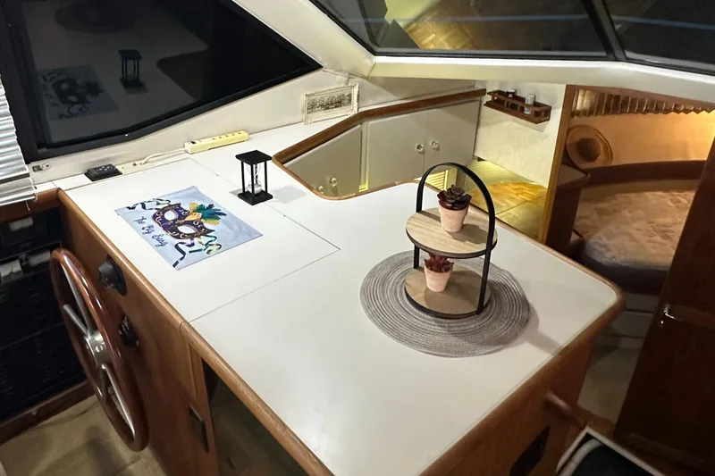 Slide: The Image of 1991 Carver 33 Aft Cabin interior with helm, decor, and cozy cabin view. - 24