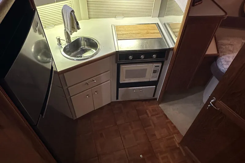 Slide: The Image of Compact kitchen in 1991 Carver 33 Aft Cabin yacht with sink, stove, and microwave. - 26
