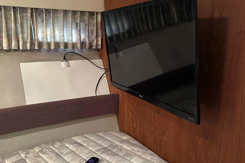 Slide: The Image of 1991 Carver 33 Aft Cabin interior with mounted TV and bed. - 30