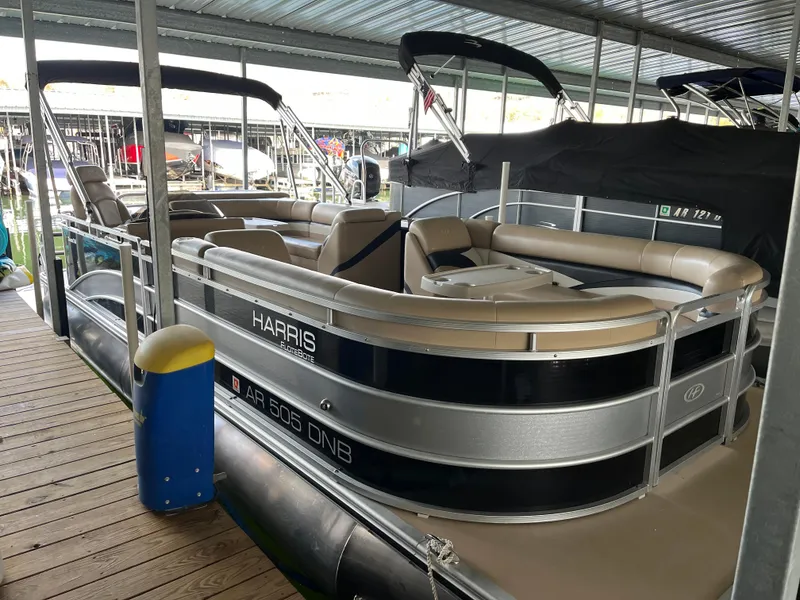 Slide: The Image of 2014 Harris Cruiser 240 pontoon boat docked under a covered marina. - 1