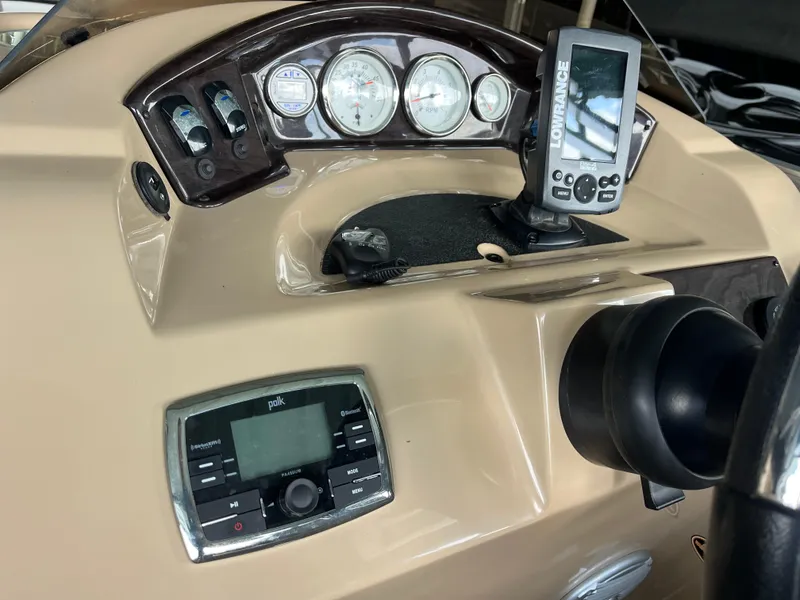 Slide: The Image of Dashboard of a 2014 Harris Cruiser 240 boat with gauges and navigation equipment. - 12