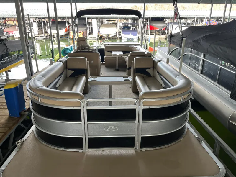 Slide: The Image of 2014 Harris Cruiser 240 pontoon boat docked, featuring spacious seating and sleek design. - 2