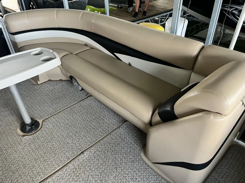 Slide: The Image of 2014 Harris Cruiser 240 boat interior with beige seating and a small table. - 6