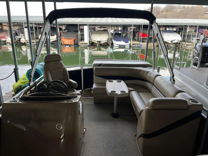 Slide: The Image of 2014 Harris Cruiser 240 pontoon boat interior at marina, featuring seating and steering console. - 7