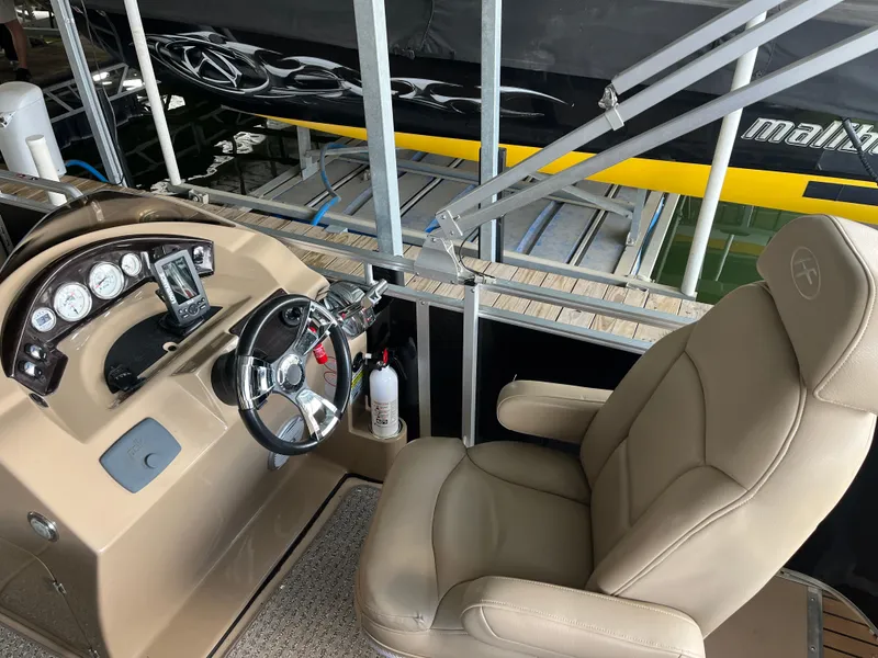 Slide: The Image of 2014 Harris Cruiser 240 boat interior with steering wheel and captain's chair. - 8