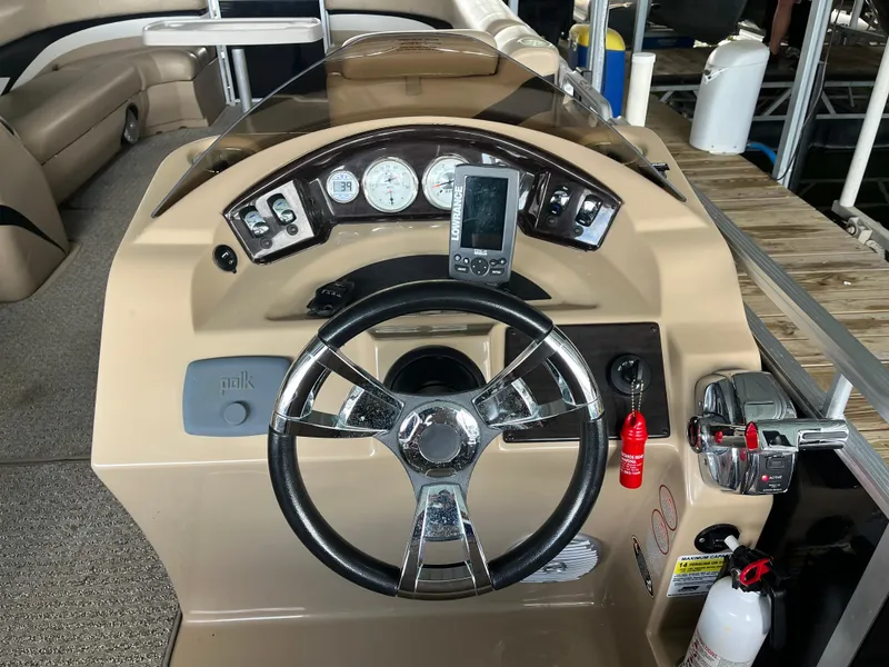 Slide: The Image of 2014 Harris Cruiser 240 boat dashboard with steering wheel and control panel. - 9