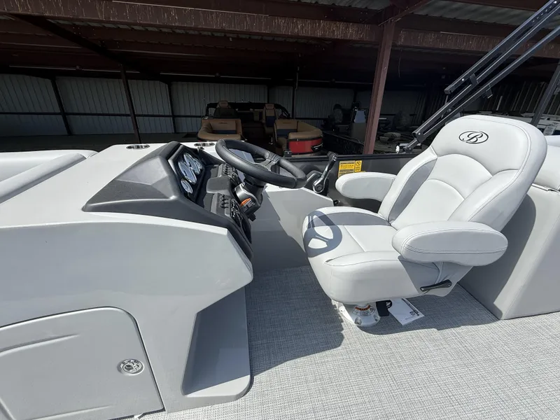 Slide: The Image of 2025 Bentley Pontoons Legacy Navigator 223 helm with luxurious captain's chair and control panel. - 13
