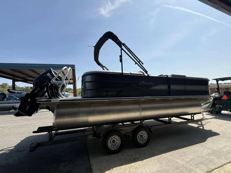 Slide: The Image of 2025 Bentley Pontoons Legacy Navigator 223 on trailer, side view under clear sky. - 3