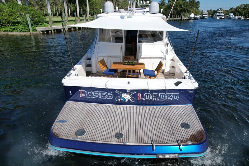 Slide: The Image of 1999 Uniesse 57 Open yacht on water, rear view with deck and seating area. - 15