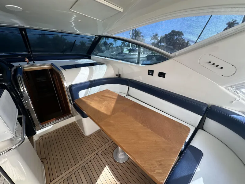 Slide: The Image of Interior of 1999 Uniesse 57 Open yacht with wooden table and blue seating. - 25