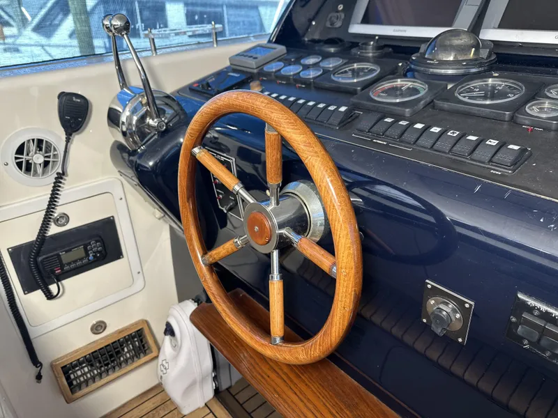 Slide: The Image of Control panel of a 1999 Uniesse 57 Open yacht with wooden steering wheel. - 36