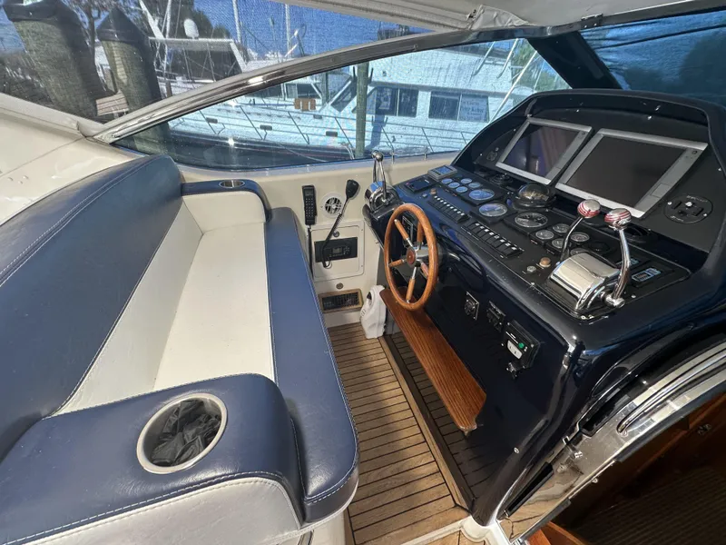 Slide: The Image of Cockpit of 1999 Uniesse 57 Open yacht with steering wheel and navigation controls. - 37