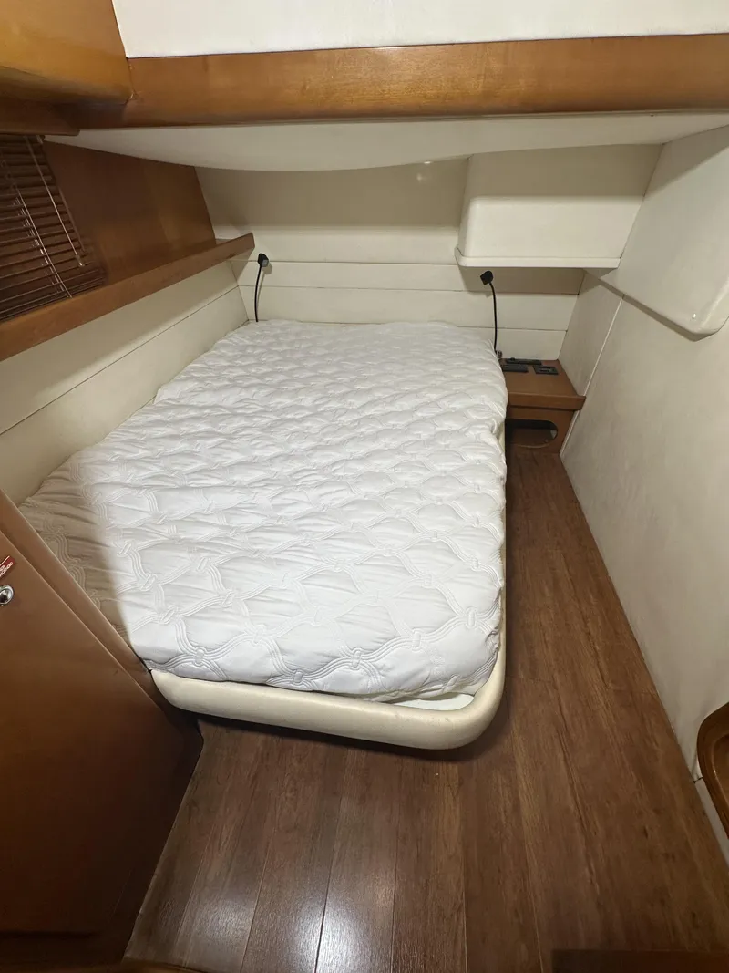 Slide: The Image of 1999 Uniesse 57 Open yacht cabin with a cozy bed and wooden flooring. - 48