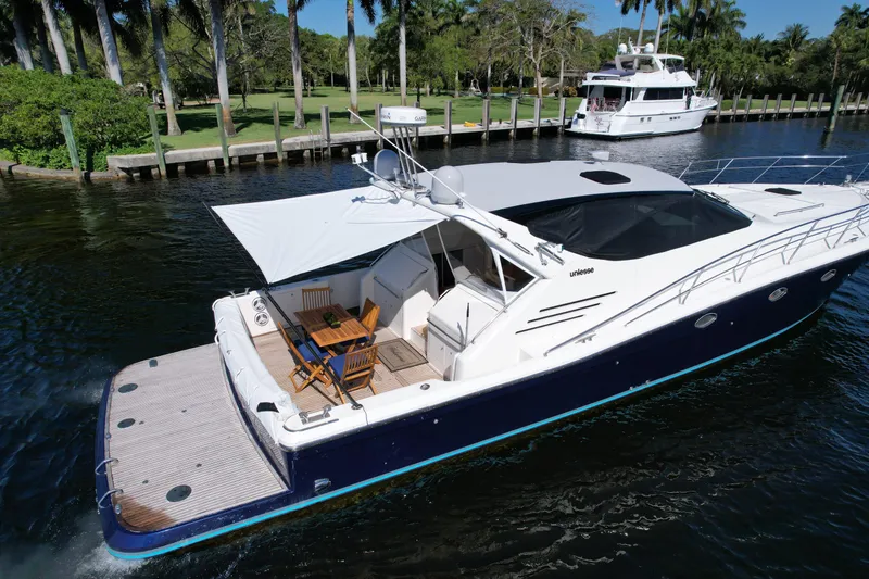 Slide: The Image of 1999 Uniesse 57 Open yacht cruising on a serene waterway, surrounded by lush greenery. - 8