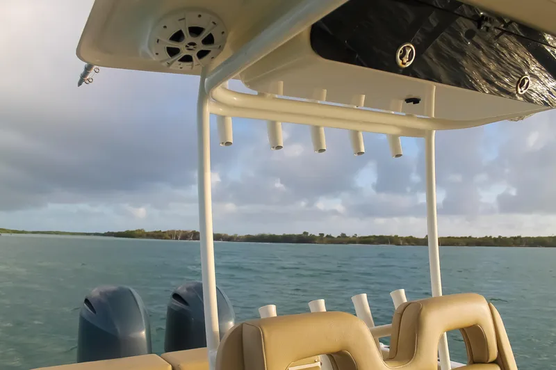 Slide: The Image of 2017 Key West Billistic 261 Center Console boat on calm waters, featuring dual engines and rod holders. - 25