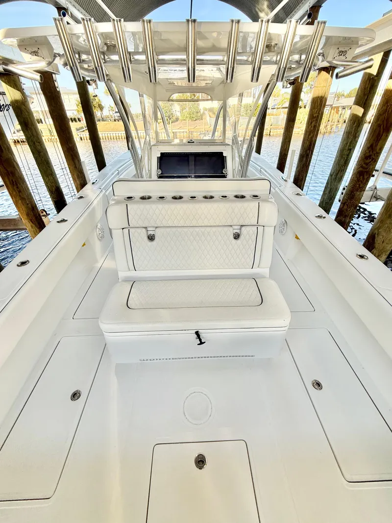 Slide: The Image of 2021 SeaHunter 35 Tournament boat interior with seating and console, docked by wooden pilings. - 12