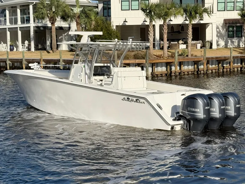 Slide: The Image of 2021 SeaHunter 35 Tournament boat with triple Yamaha engines on a sunny waterfront. - 4