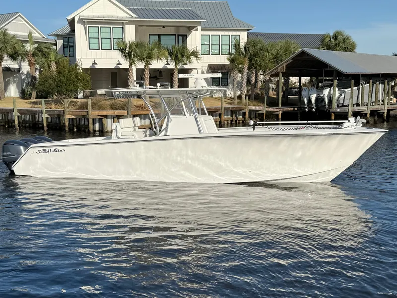 Slide: The Image of 2021 SeaHunter 35 Tournament boat on calm water near waterfront homes. - 7
