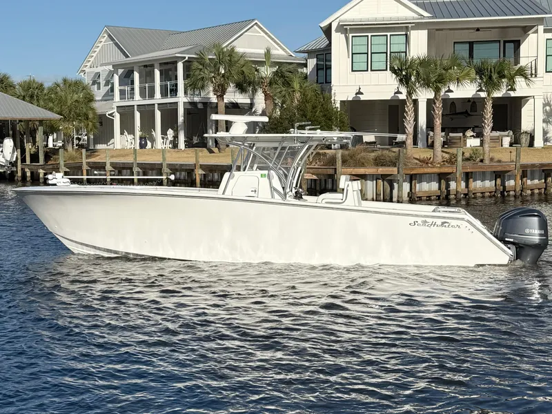 Slide: The Image of 2021 SeaHunter 35 Tournament boat docked near waterfront homes, under clear blue sky. - 8