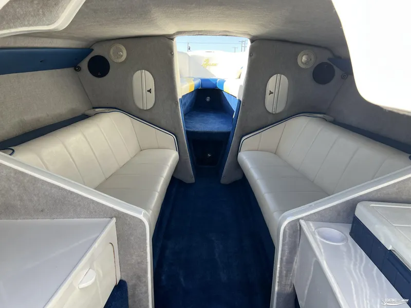Slide: The Image of Interior of a 2002 Nordic 28 Heat MCOB boat with white seating and blue carpet. - 12