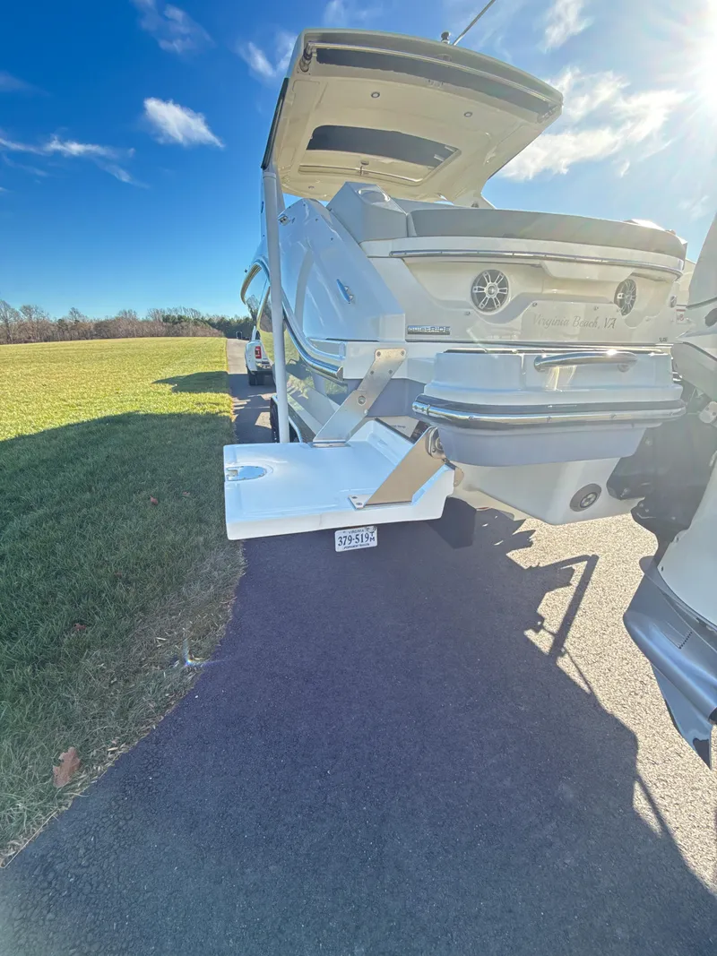 Slide: The Image of 2023 Sea Ray SLX 310 OB boat on trailer, sunny day, grassy field background. - 14
