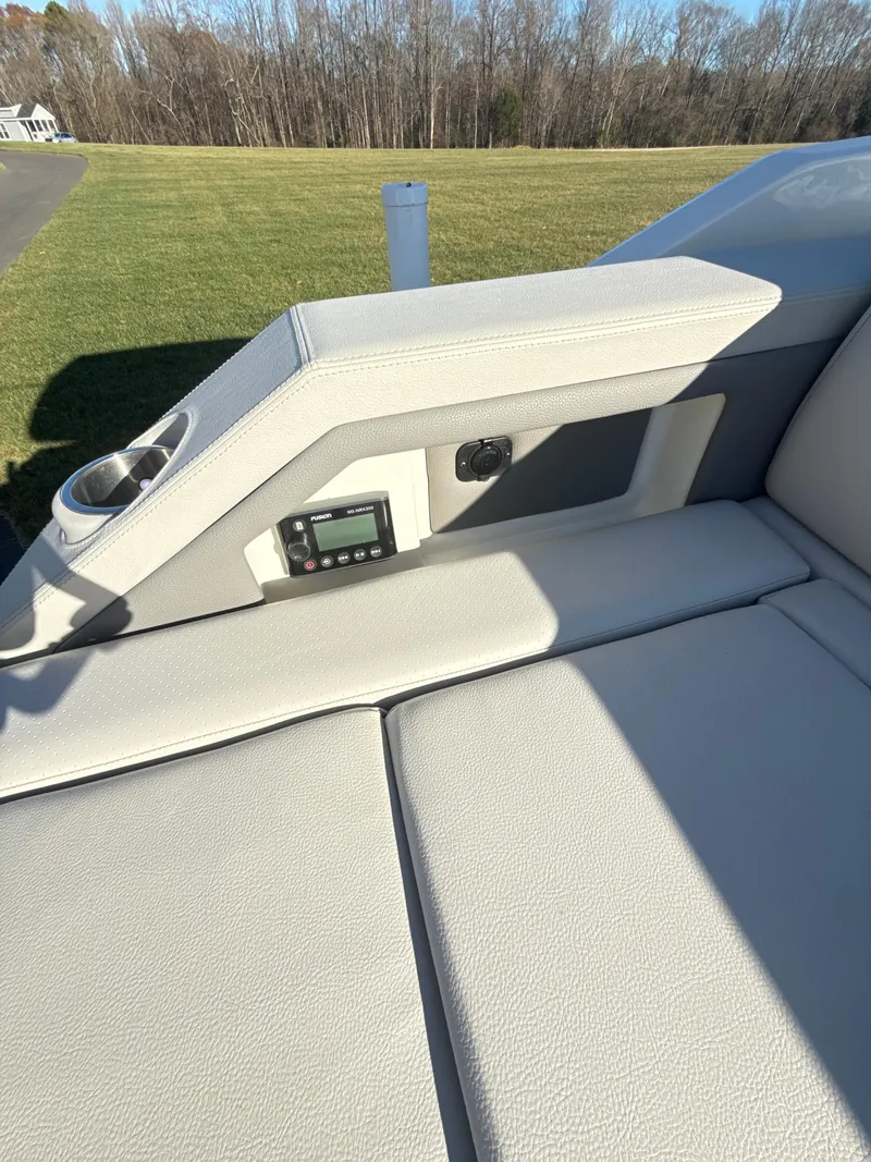 Slide: The Image of 2023 Sea Ray SLX 310 OB boat interior with cushioned seating and control panel. - 24