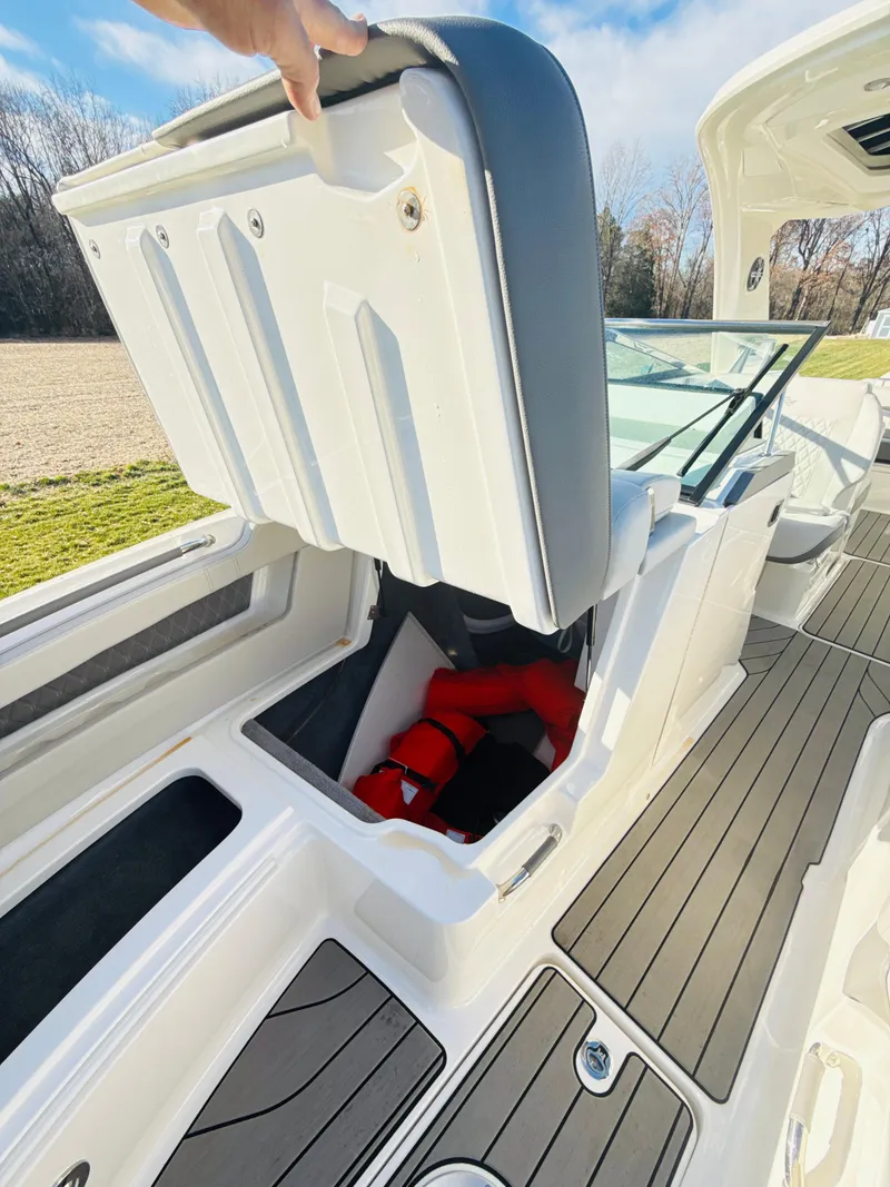 Slide: The Image of 2023 Sea Ray SLX 310 OB boat with open storage compartment and life jackets. - 35