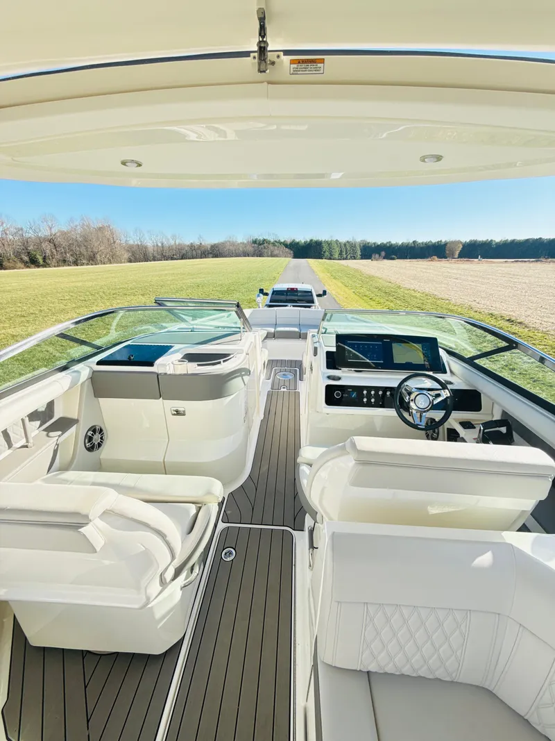 Slide: The Image of 2023 Sea Ray SLX 310 OB boat interior with luxurious seating and modern dashboard. - 37