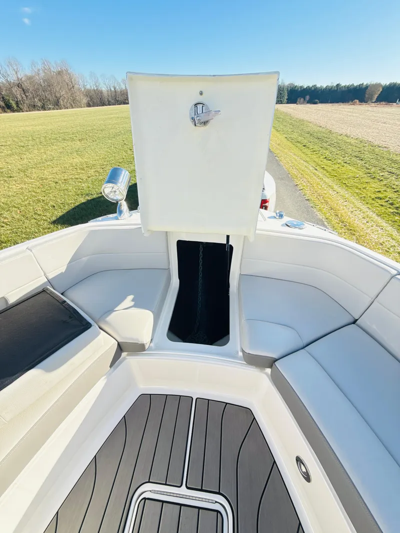 Slide: The Image of 2023 Sea Ray SLX 310 OB boat interior with open storage compartment, white seating, and gray flooring. - 39
