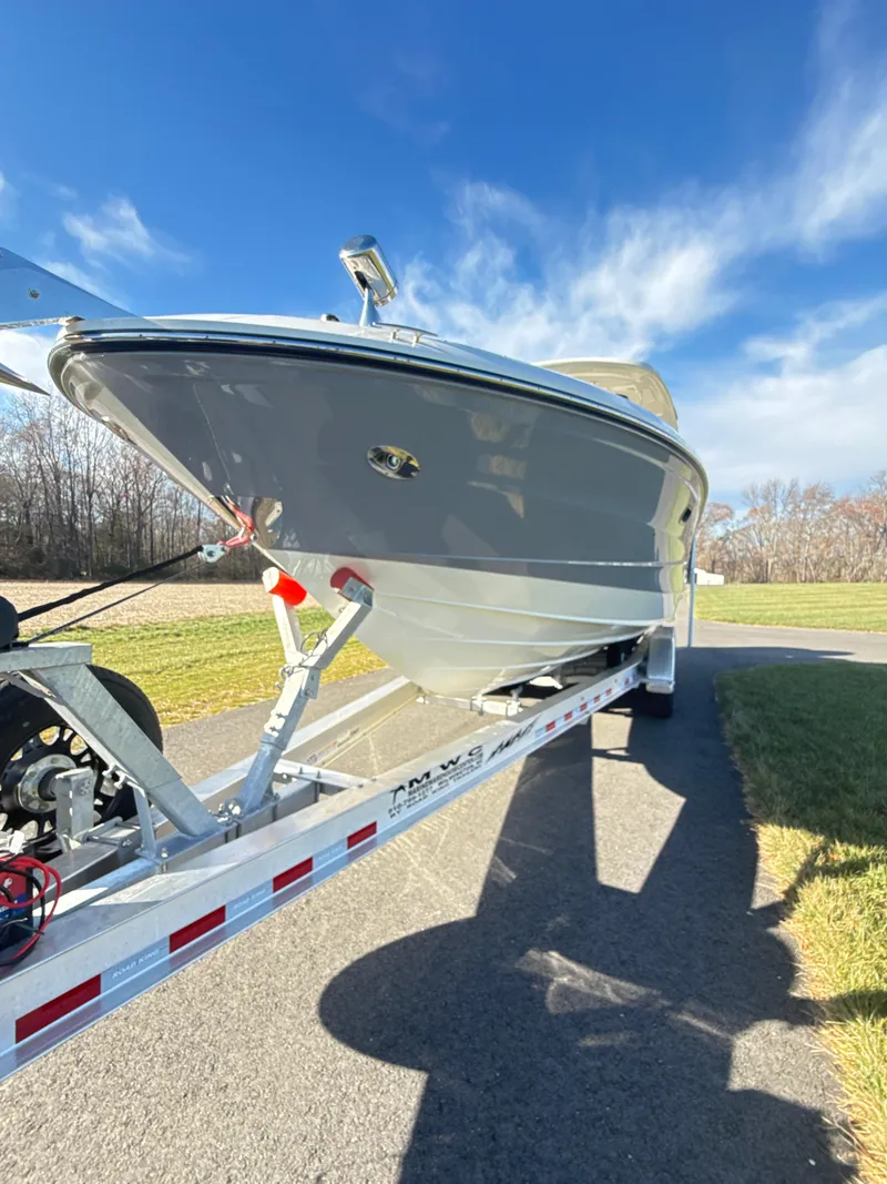 Slide: The Image of 2023 Sea Ray SLX 310 OB boat on trailer, parked outdoors under clear blue sky. - 43
