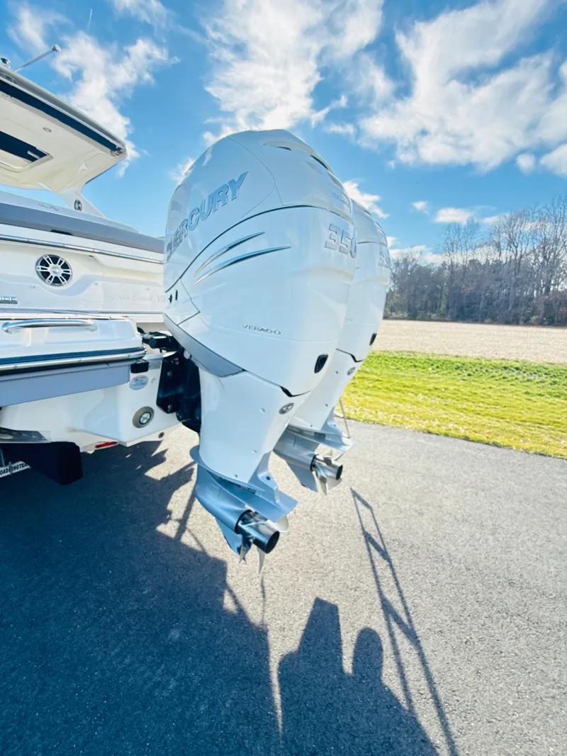 Slide: The Image of 2023 Sea Ray SLX 310 OB with dual Mercury outboard engines, parked on a sunny day. - 8