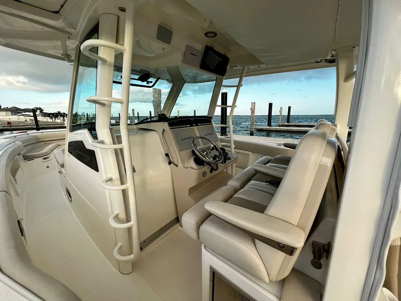 Slide: The Image of 2019 Boston Whaler 380 Outrage interior with helm, seating, and ocean view. - 11