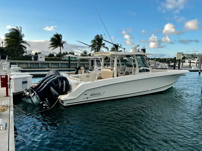 Slide: The Image of 2019 Boston Whaler 380 Outrage docked, featuring twin outboard engines, under a clear blue sky. - 16