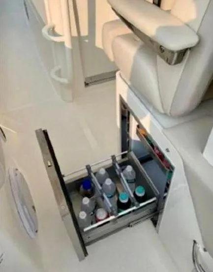 Slide: The Image of 2019 Boston Whaler 380 Outrage boat with open storage drawer containing bottles. - 19