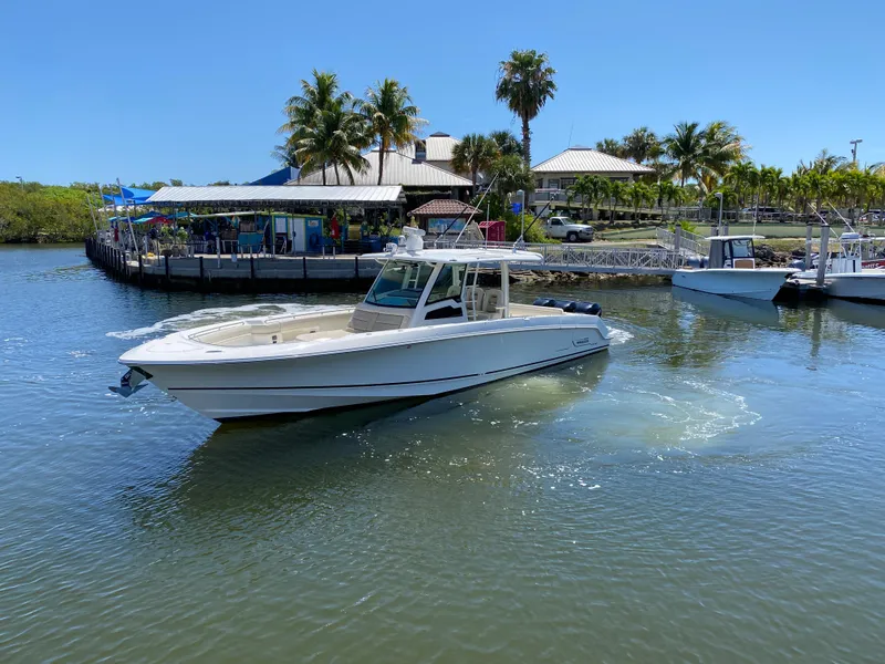 Slide: The Image of 2019 Boston Whaler 380 Outrage boat on water near tropical marina. - 7