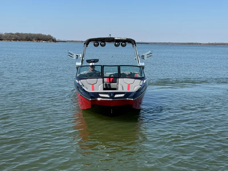 Slide: The Image of 2022 MasterCraft XT24 boat on calm lake waters, front view. - 3