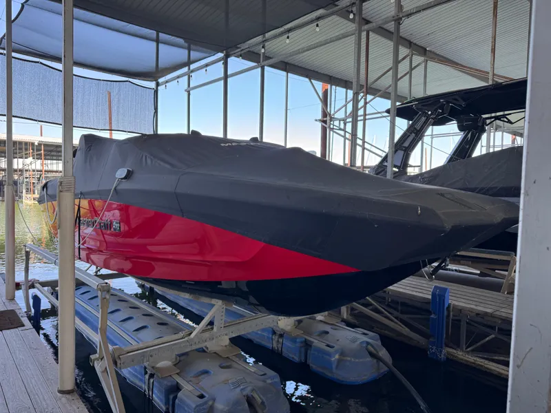 Slide: The Image of 2022 MasterCraft XT24 boat covered and docked in a marina. - 35